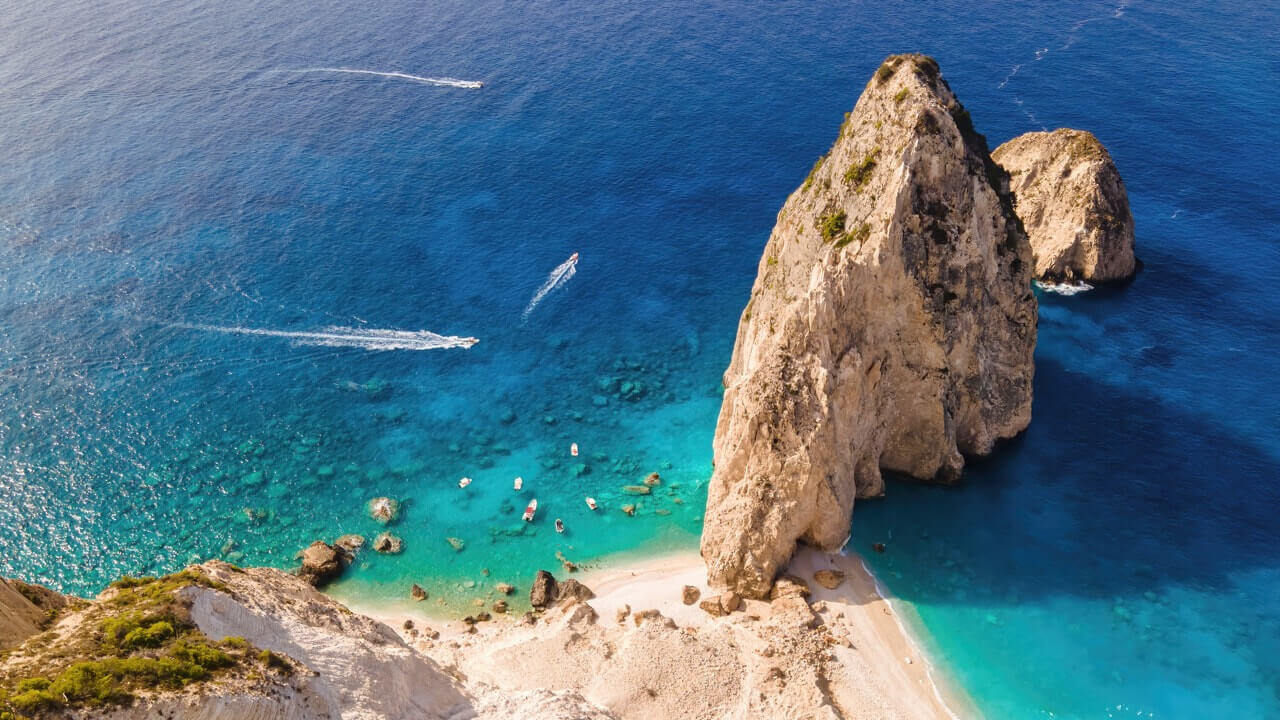 aerial drone view ionian sea coast zakynthos greece rocky ridge beach floating boats Large