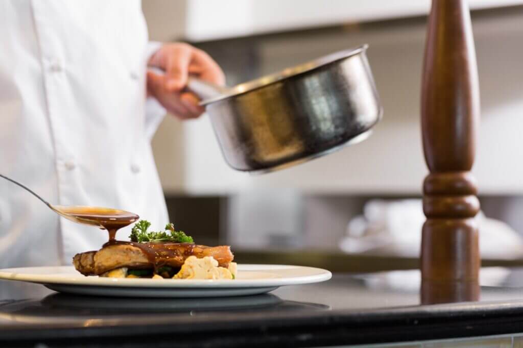 closeup mid section chef garnishing food Large
