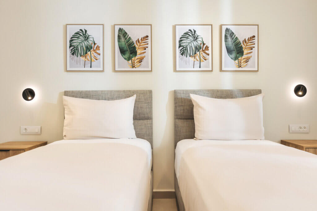 Twin beds accented with chic botanical prints create a charming and inviting space.