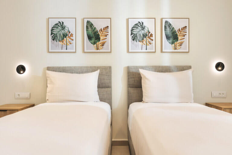 Twin beds accented with chic botanical prints create a charming and inviting space.