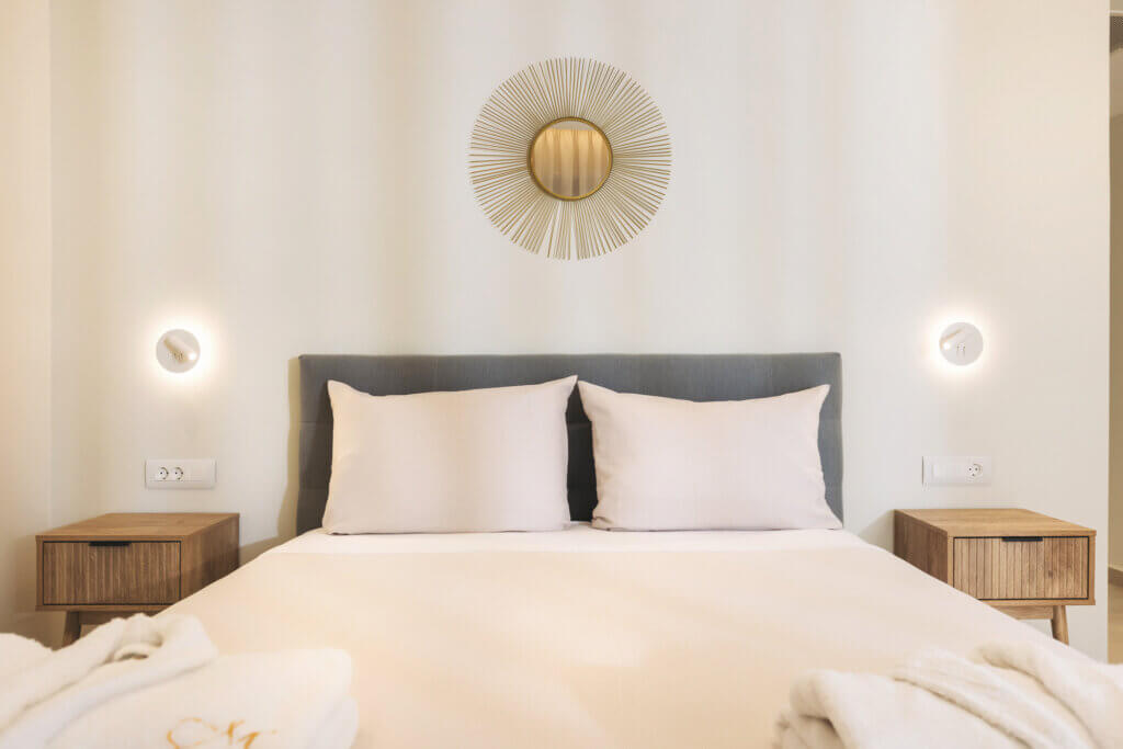 With its plush headboard and fine linens, this room is a haven for relaxation. Modern bedside lighting and a striking sunburst mirror add a touch of sophistication to your peaceful retreat.